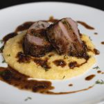 herbed pork loin with polenta and pan sauce plated side view