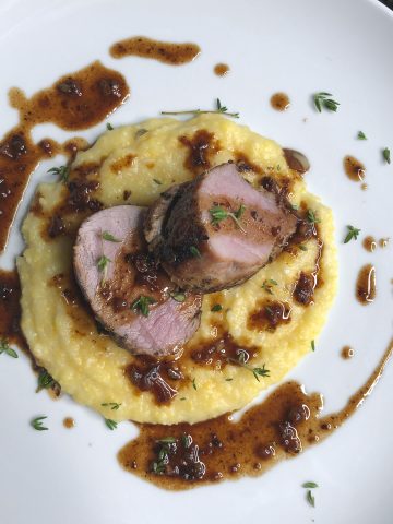 herbed pork loin with polenta and pan sauce plated vertical