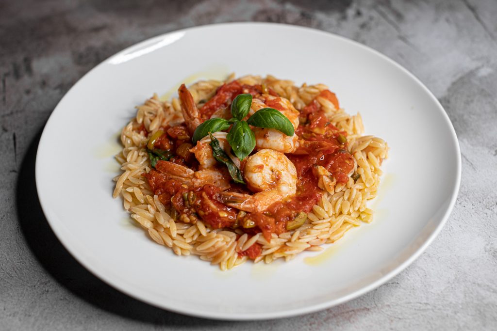 plated shrimp with orzo and red sauce