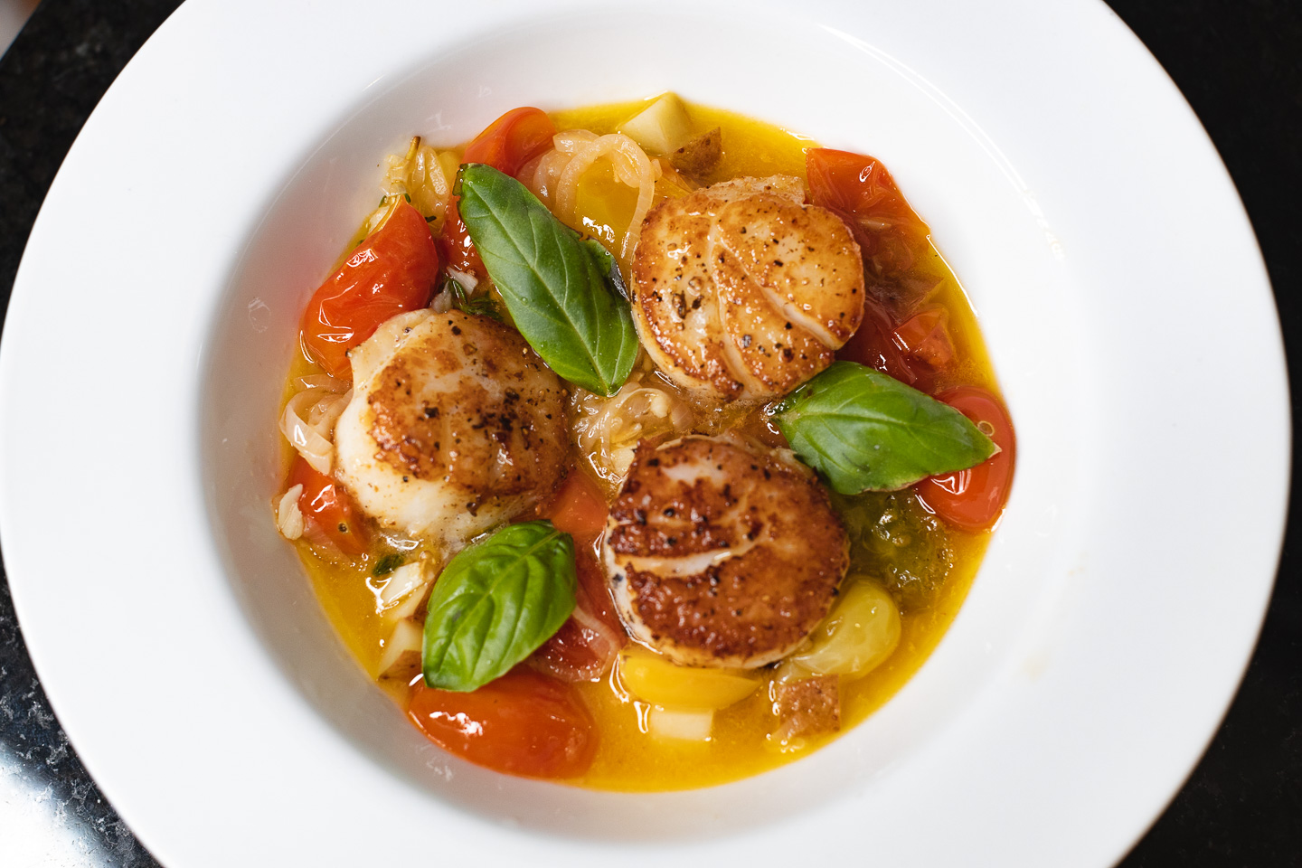 scallops with tomato butter wine sauce in bowl