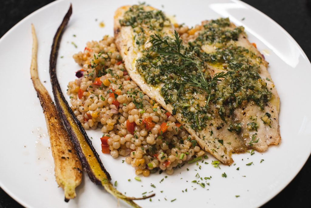 finished and plated tilapia and carrot top pesto with israeli couscous and carrots
