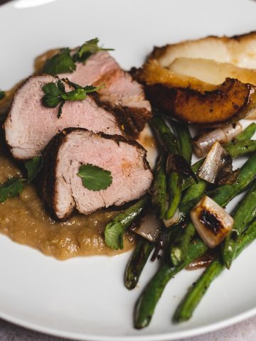 side view finished plate pork tenderloin with pear sauce green beans and shallot