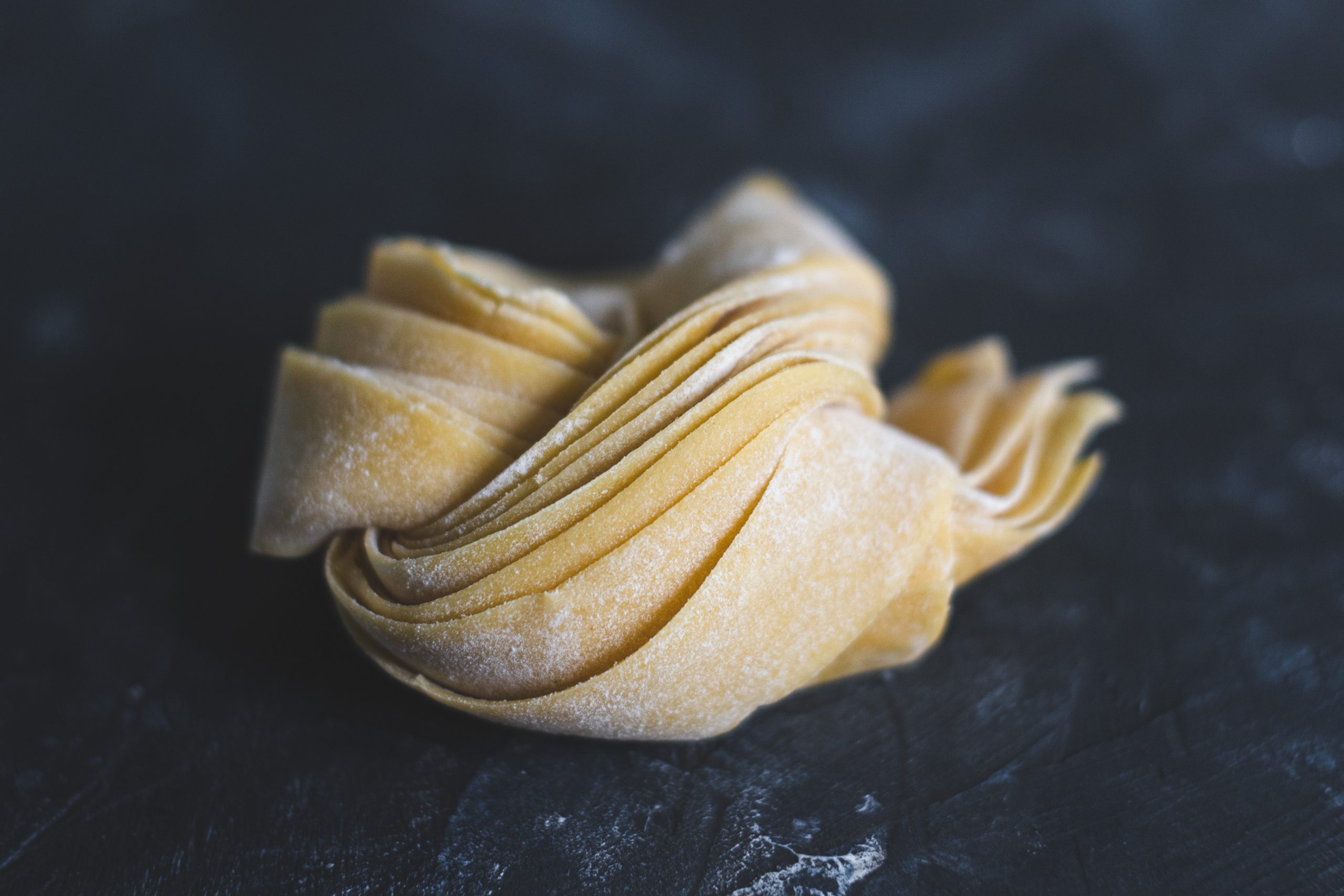 closeup of pappardelle pasta rolled into a nest